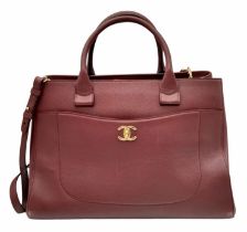 A Chanel Neo Executive Leather Tote Bag. Burgundy leather exterior with gold tone hardware and two