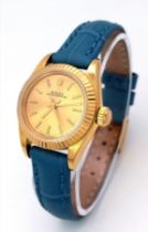 An 18k Gold Rolex Oyster Perpetual Ladies Watch. Blue leather strap. 18k gold case - 25mm. Gold tone