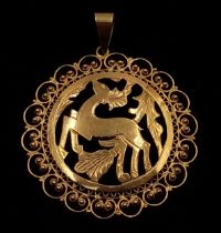 A very elegant, 18 K yellow gold pendant with a deer and vegetation surrounded by refined