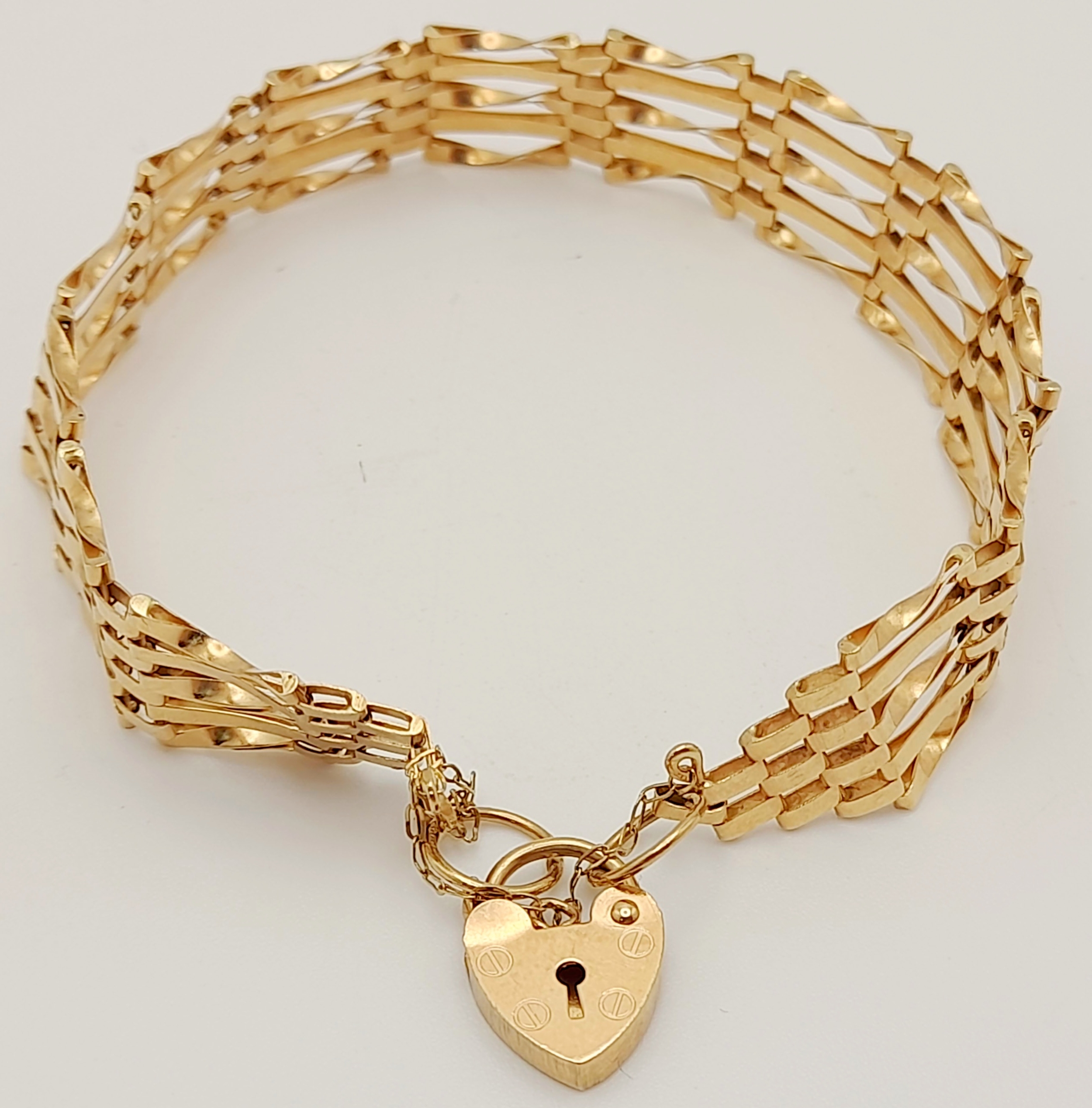 A 9 K yellow gold bracelet with a padlock clasp and safety chain, length: 18 cm, weight: 5.9 g.