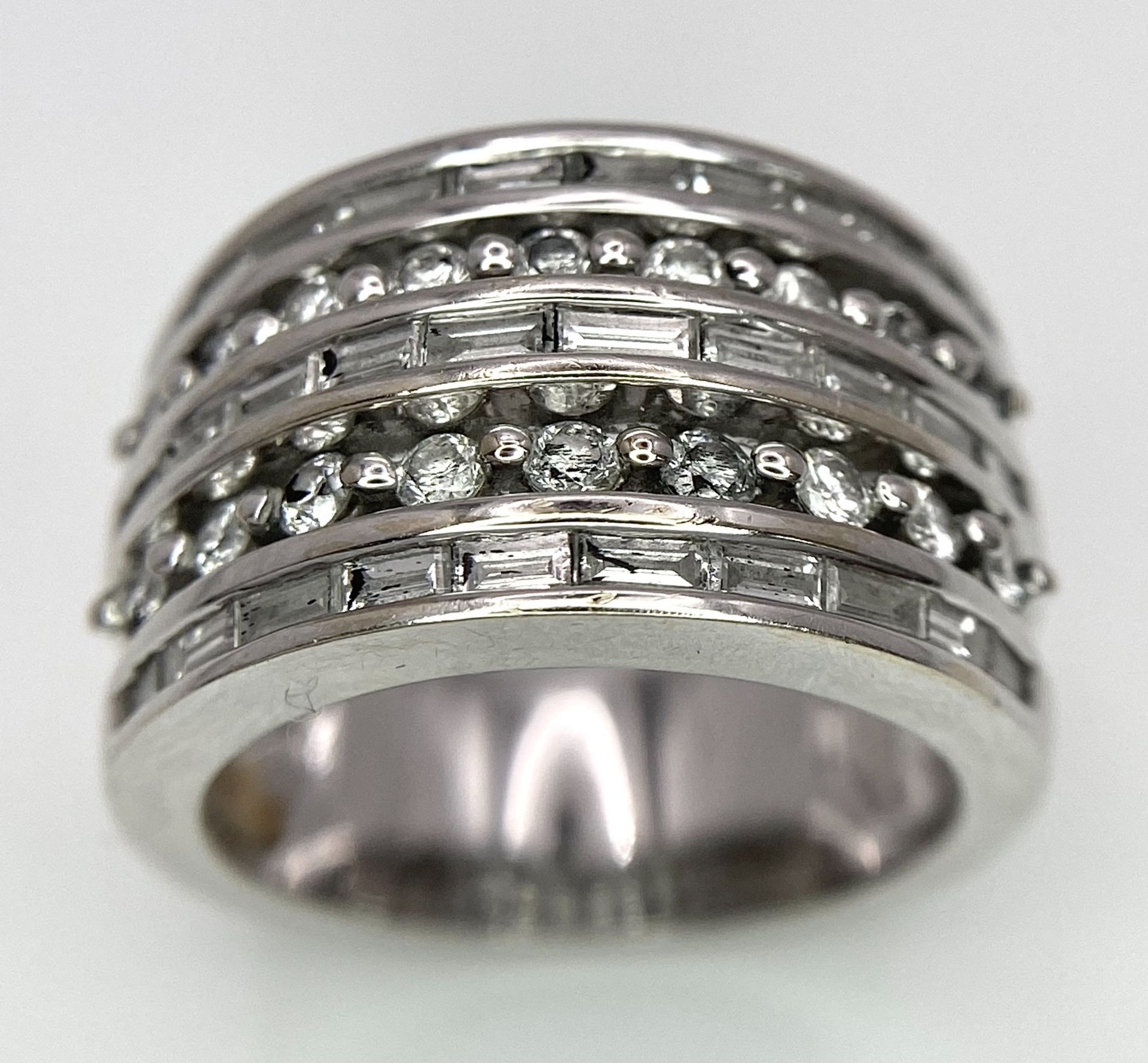 AN 18K WHITE GOLD 5 ROW DIAMOND RING. MIXTURE OF ROUND BRILLIANT CUTS AND BAGUETTE CUT DIAMONDS.