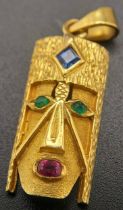 A 18K (STAMPED AND TESTED AS) YELLOW GOLD CONGOLESE MASK PENDANT SET WITH SAPPHIRE, EMERALDS AND