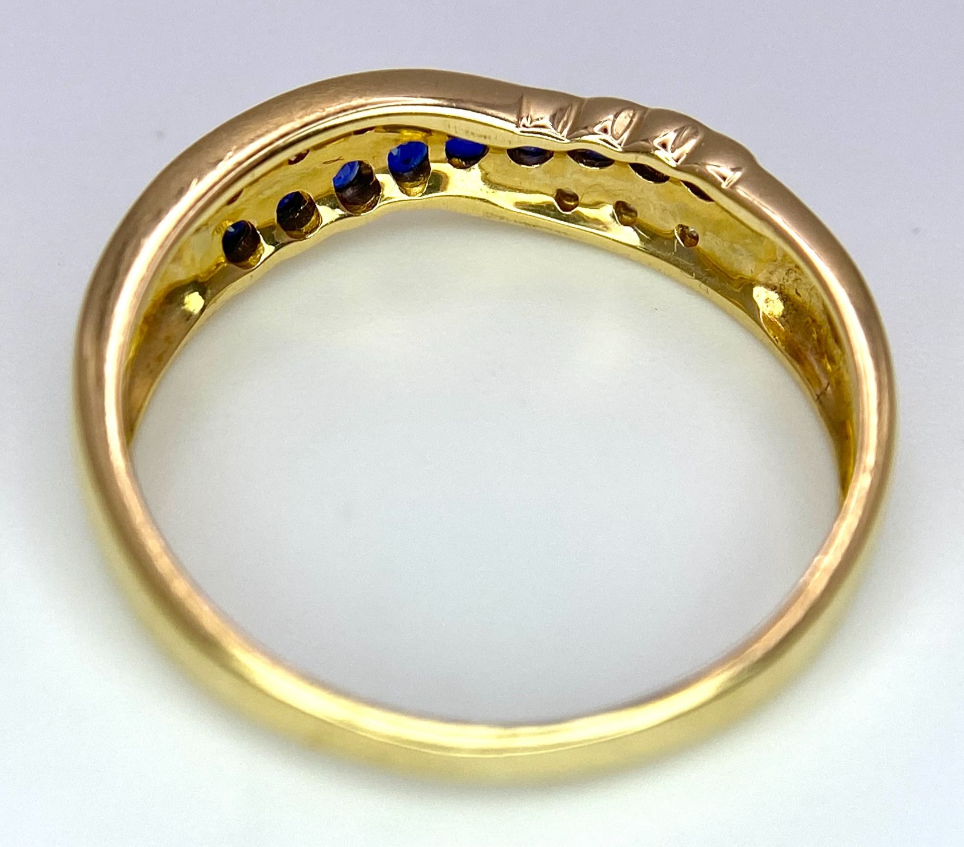 AN 18K YELLOW GOLD DIAMOND & BLUE STONE (PROBABLY SAPPHIRE) CROSSOVER RING. Size O, 2.7g total - Image 4 of 6