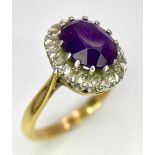 An 18K Yellow Gold Amethyst and Diamond Ring. Central amethyst with a diamond halo. Size M. 4.4g