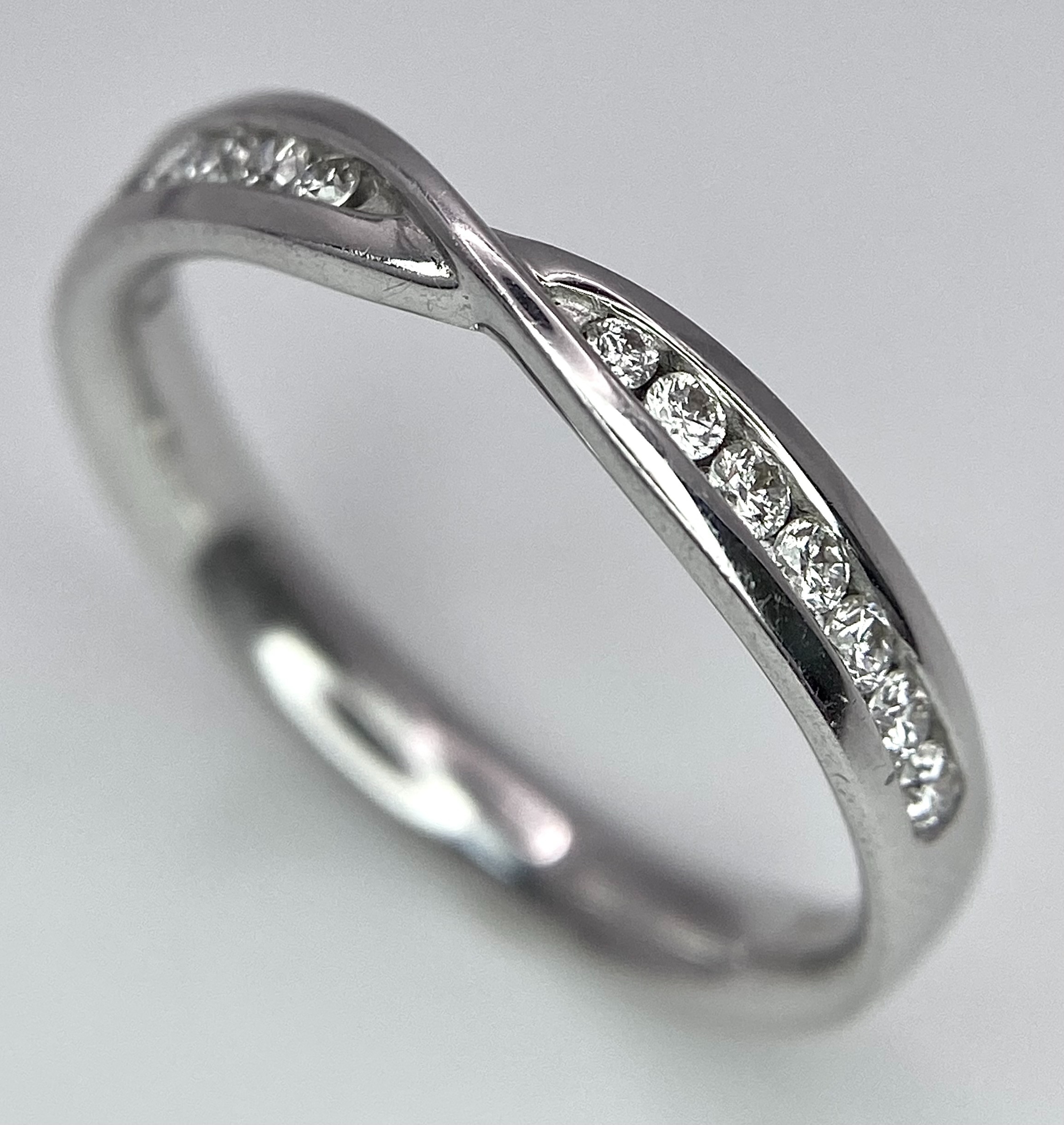 AN 18K WHITE GOLD DIAMOND RING. 0.15CT. 2.7G. SIZE M.