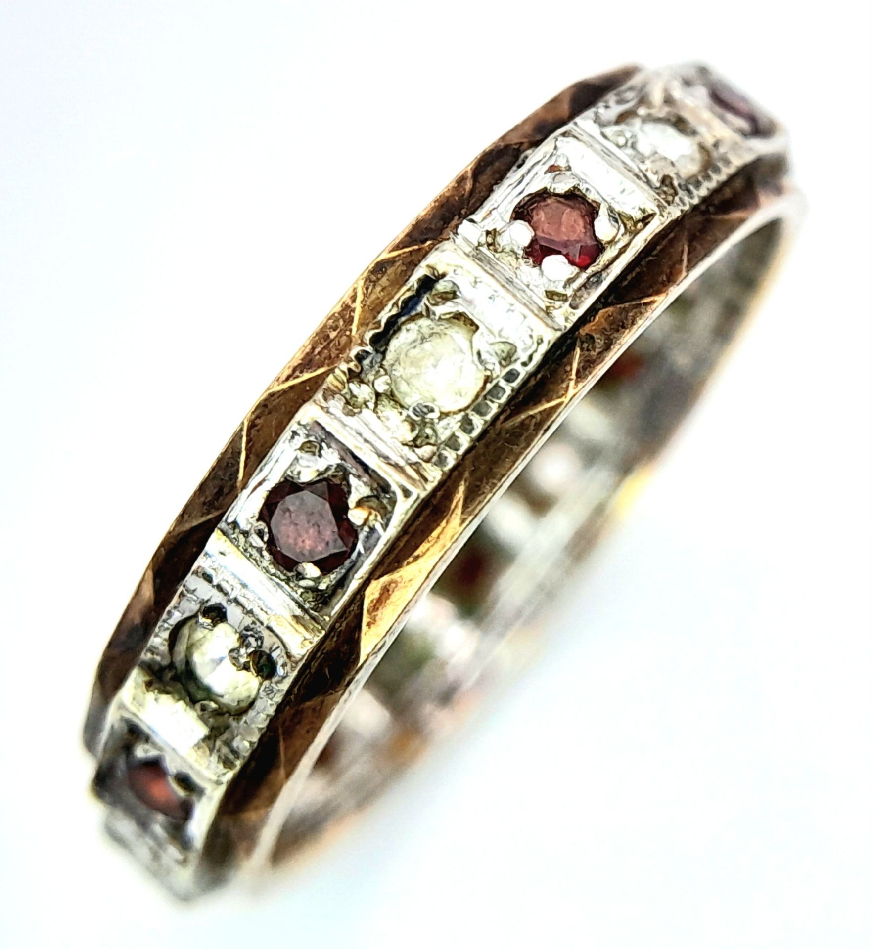 An unusual, vintage, eternity ring with alternating round cut diamonds and rubies. Size: L,