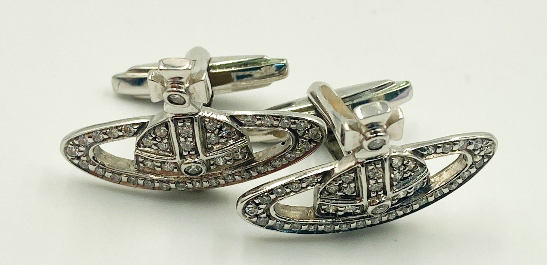 A PAIR OF 18K WHITE GOLD (STAMPED & TESTED) DIAMOND SET VIVIENNE WESTWOOD CUFFLINKS. 2.5cm length,