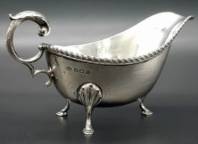 An Almost Antique Sterling Silver Gravy Boat. Scroll handle and shell decorative legs. Hallmarks for