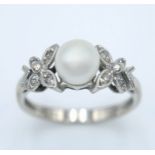 A 14K White Gold, Pearl and Diamond Ring. Central pearl with diamond accents. Size L 1/2. 2.5g total