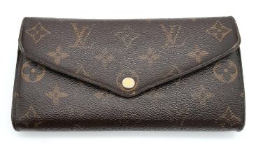 A Louis Vuitton Monogram Wallet. Leather exterior with an open compartment on back and press stud