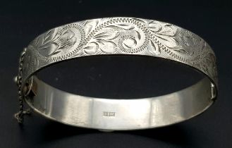 A VINTAGE SOLID SILVER HINGED BANGLE WITH ENGRAVING ALL AROUND . 30gms