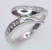 A 9K White Gold (tested) Diamond Crossover Ring. Size I. 2.6g total weight.