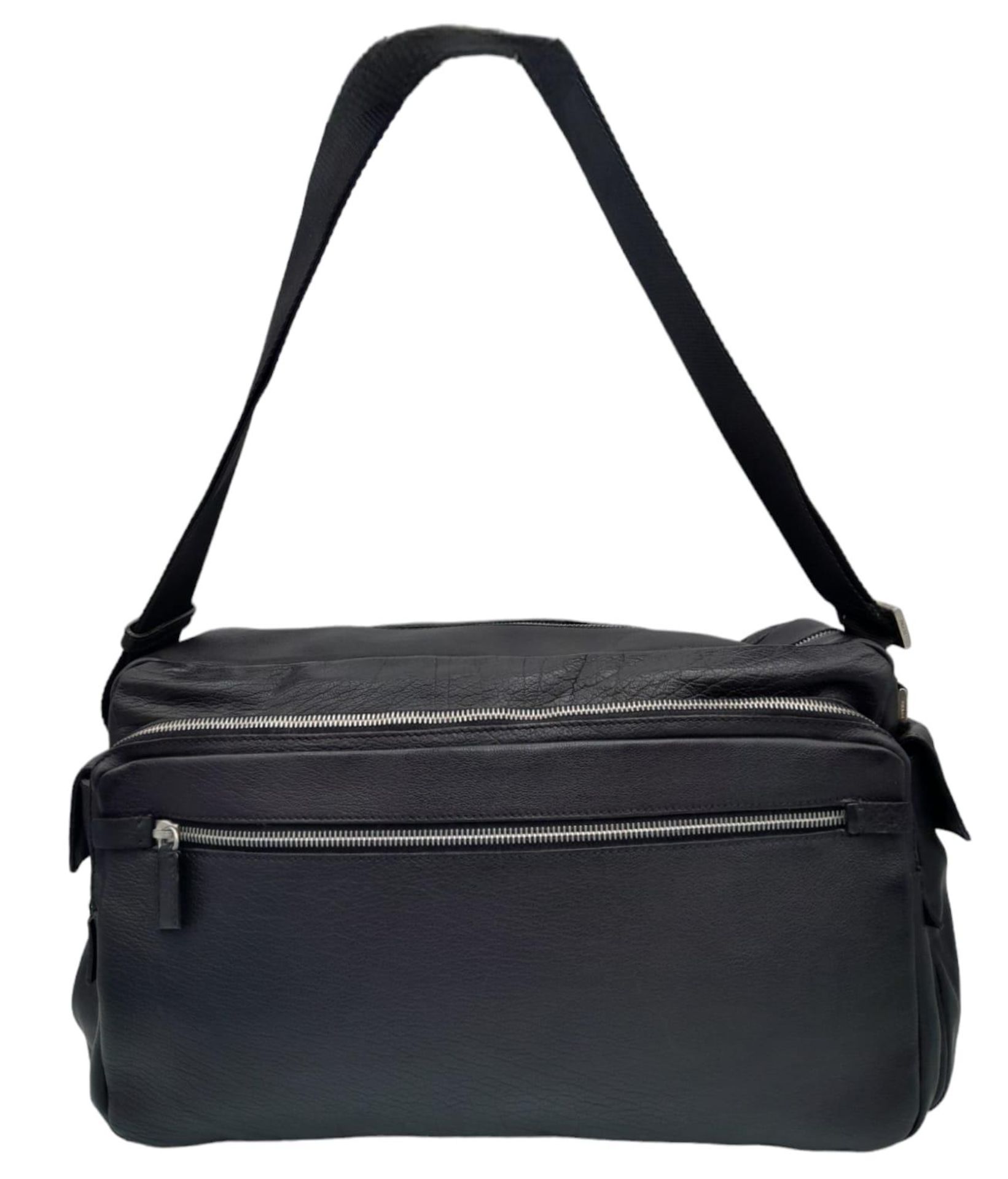 A Prada Black Duffle Bag. Leather exterior with silver-toned hardware, zipped outer compartment to
