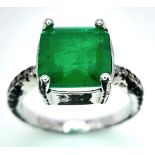 A sterling silver ring with an emerald cut green stone and cubic zirconia on the shoulders. Size: N,