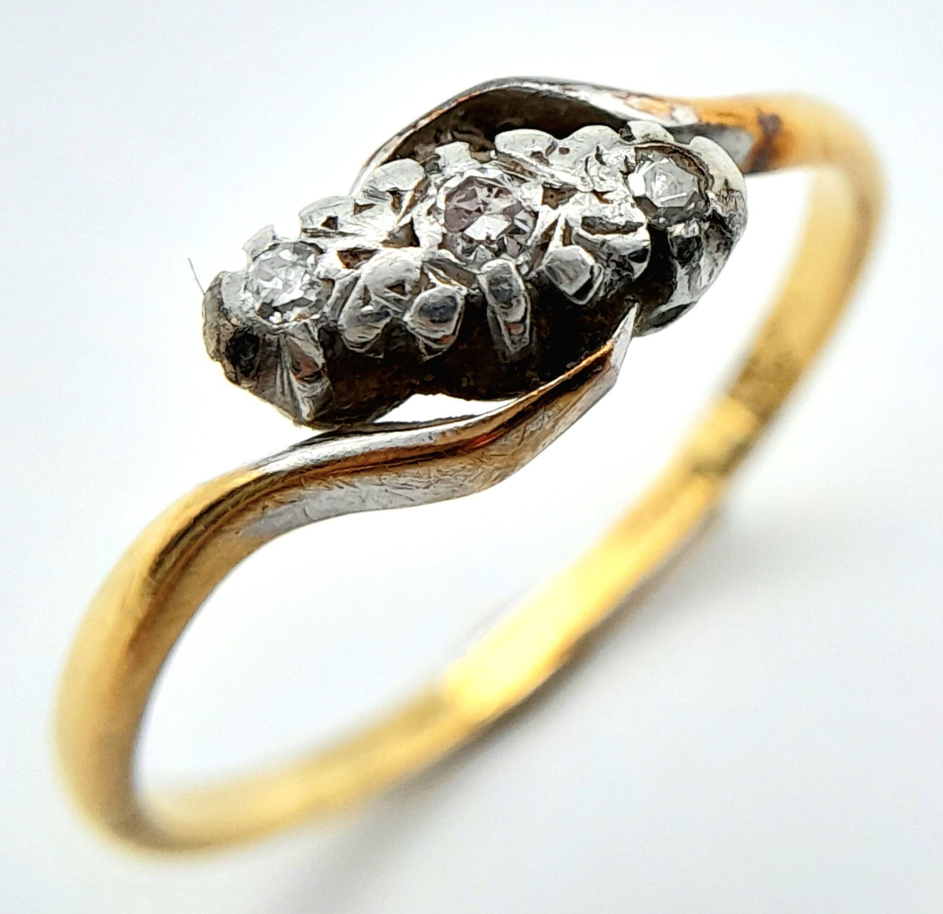 A vintage, 18 K yellow gold ring with a trilogy of round cut diamonds in a twisted design. Ring - Bild 4 aus 7