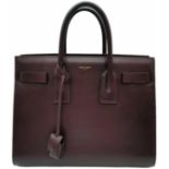 A Saint Laurent Sac De Jour Burgundy Handbag. Leather Exterior, Gold Tone Hardware, Double Handle in