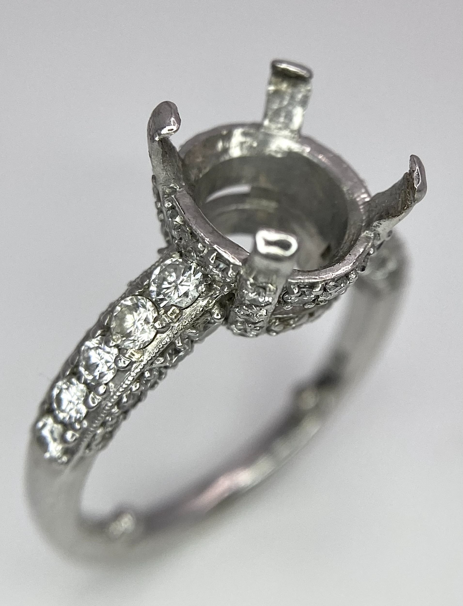 AN 18K WHITE GOLD 4 CLAW SINGLE STONE RING WITH DIAMOND SET BEZEL, SHOULDERS AND SIDES - Ready to