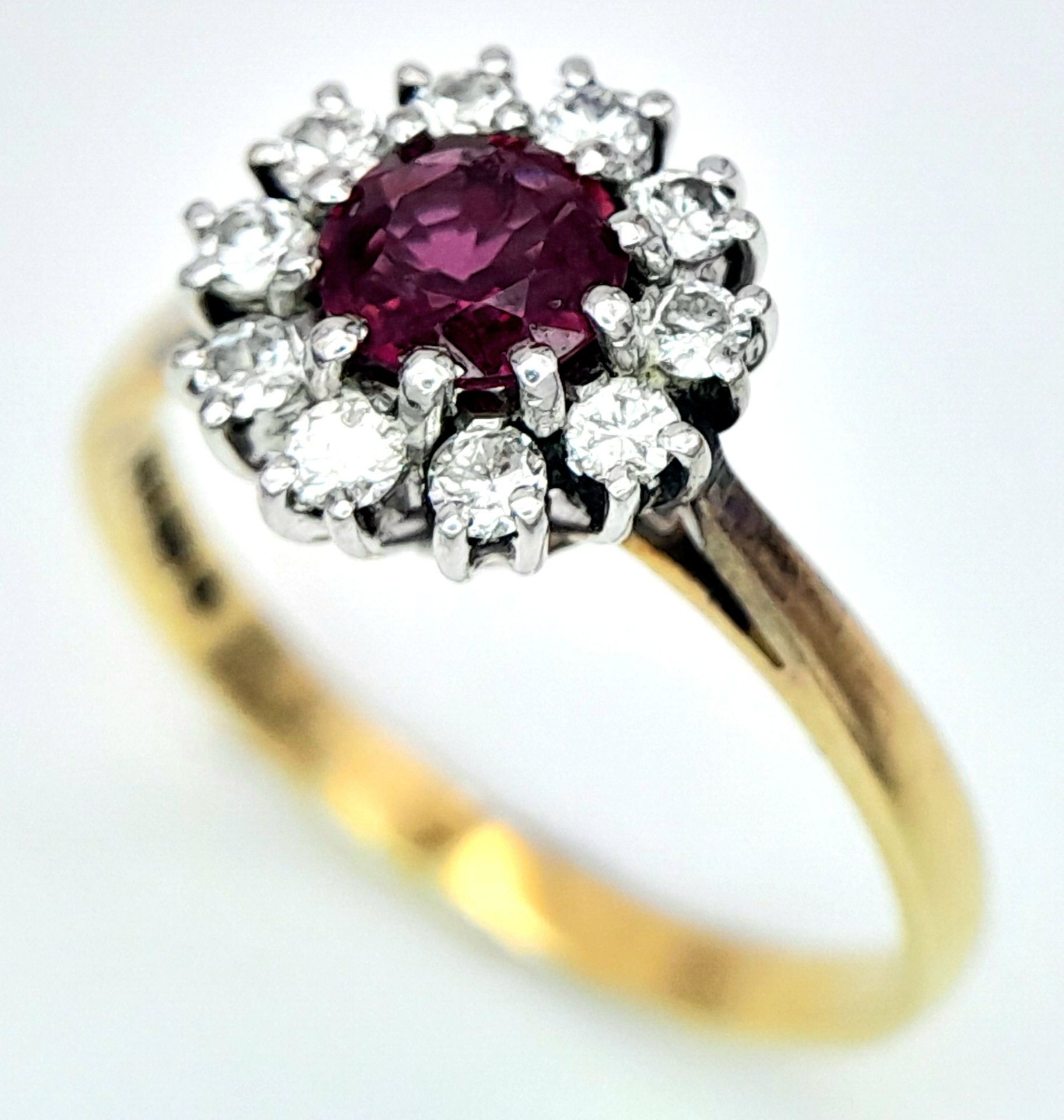 An 18K Yellow Gold, Ruby and Diamond Ring. Round cut ruby with a diamond halo. Size M 1/2. 2.8g
