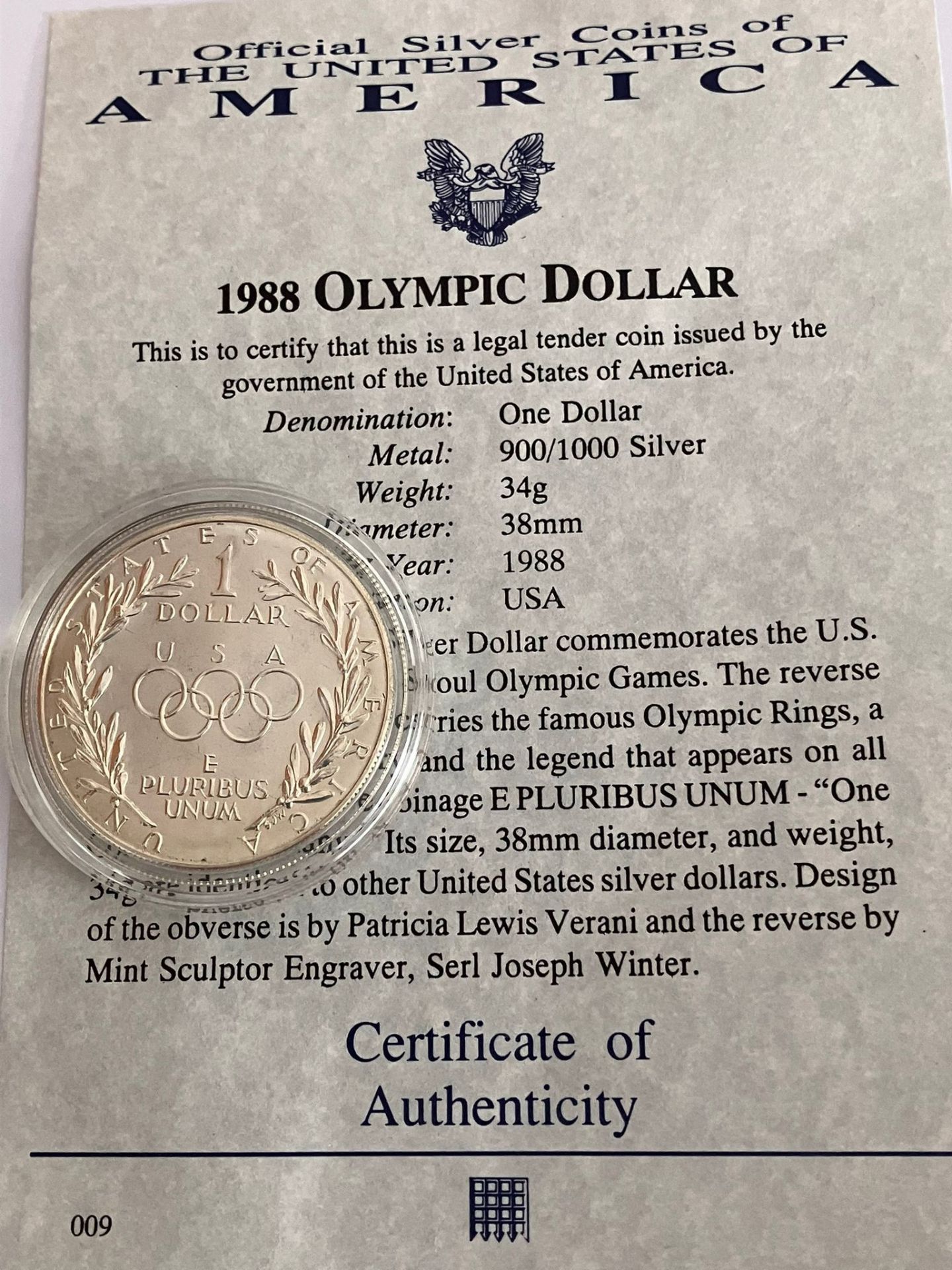 1988 OLYMPIC SILVER DOLLAR. Condition very fine ,appears a little dirty inside capsule. Complete