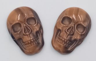 A PAIR OF TIGERS EYE CARVED MATCHING SKULLS - VERY RARE AND UNUSUAL. 20MM X 15.5MM