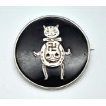An antique sterling silver brooch with a good luck cut on a black background. Diameter: 26 mm,