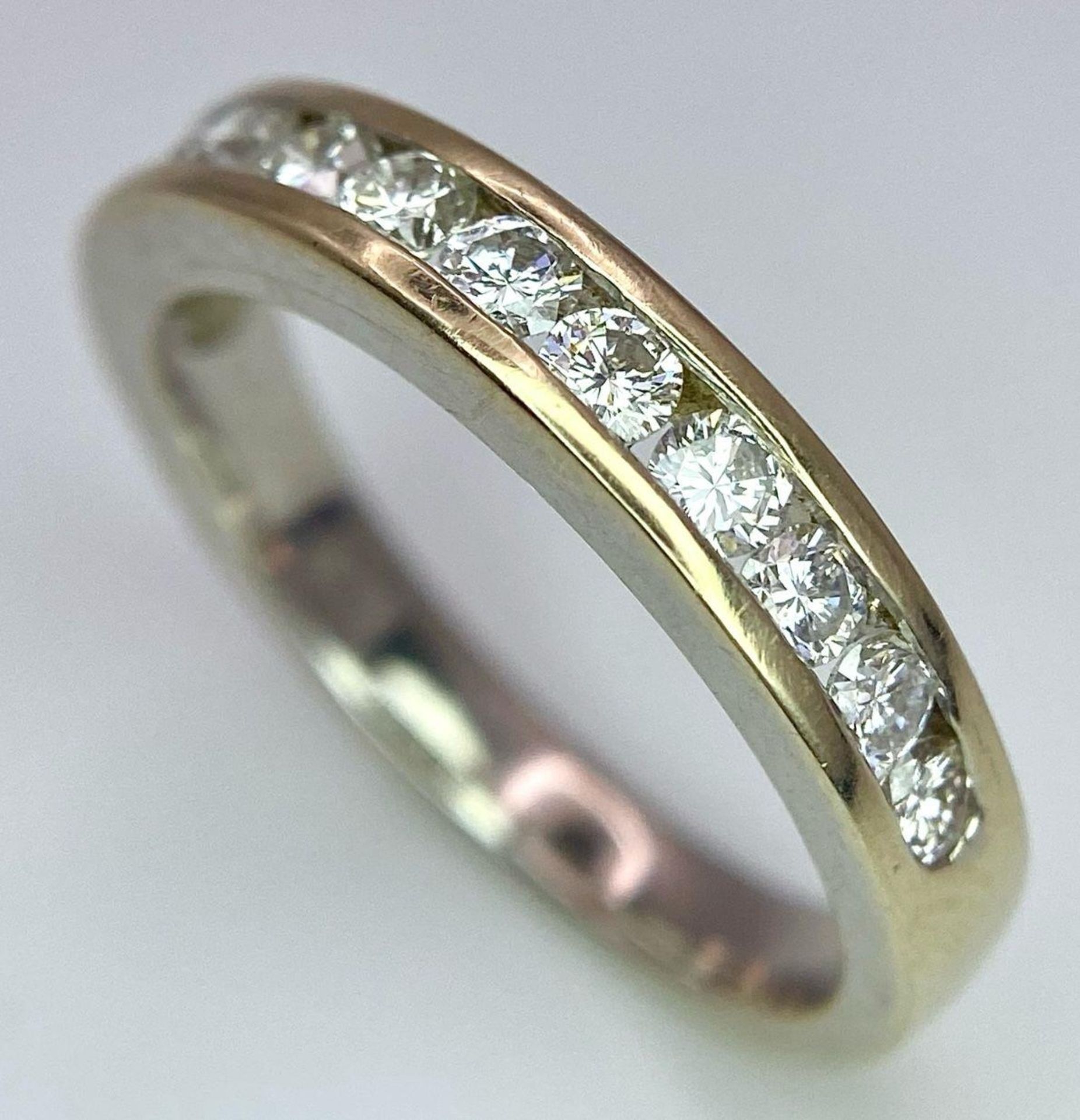 An 18K Yellow Gold Diamond Half Eternity Ring. 12 brilliant round cut diamonds - 0.60ctw. Size N.