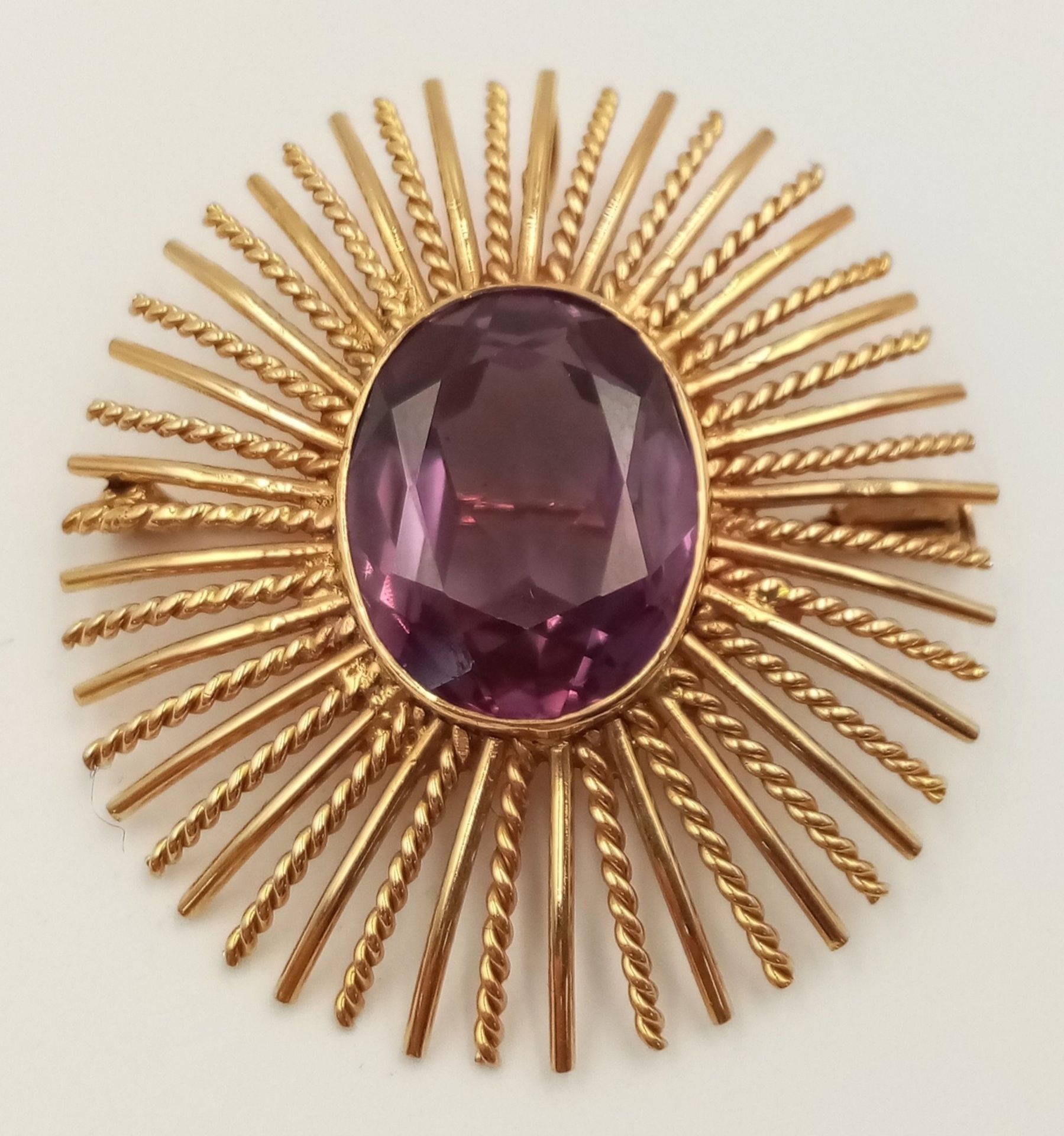 A 16K (TESTED AS) YELLOW GOLD STARBURST DESIGN BROOCH ALSO WITH PENDANT BAIL, SET WITH A 2CM X 1.5CM