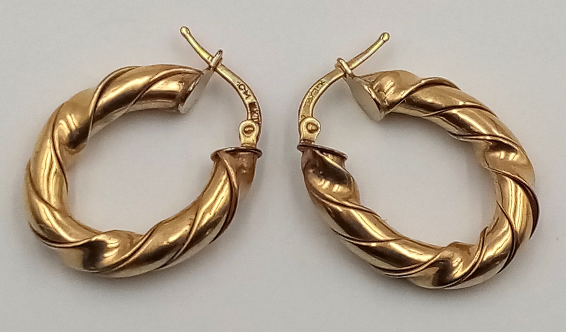 A 9 K yellow gold pair of hoop earrings with a twisted design, drop: 26 mm, total weight: 5 g.