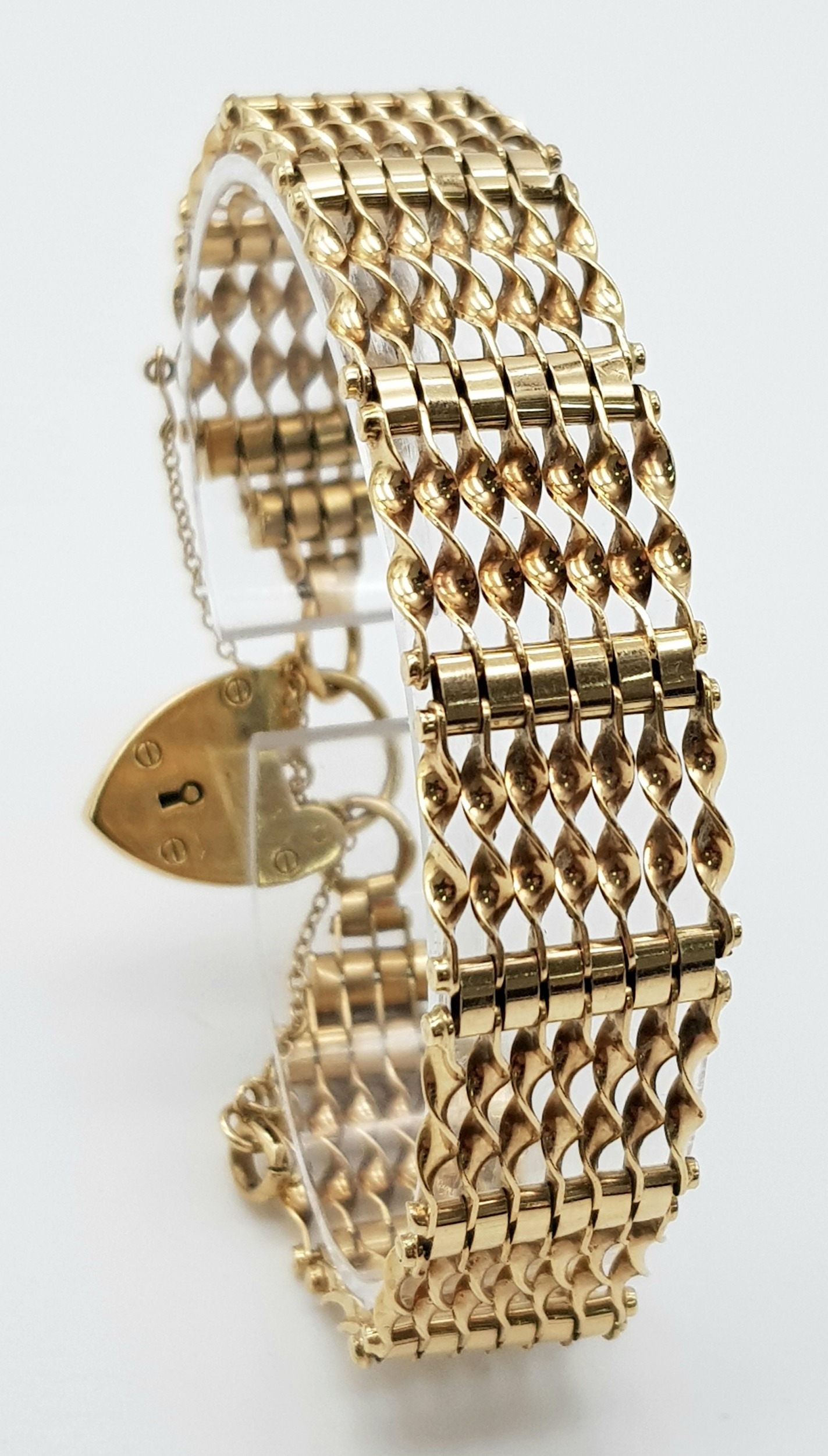 A 9K Yellow Gold gate Bracelet with Heart Clasp. 16mm width. 19.6g weight.