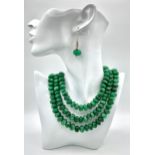 A Tibetan silver necklace with three rows of substantial round emerald cabochons accompanied by a