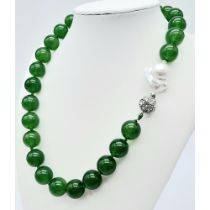 A Green Jade and Keisha Baroque Pearl Necklace. 14mm green jade beads with a baroque pearl