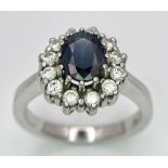 A 14K White Gold Sapphire and Diamond Ring. Oval cut central sapphire with a 0.5ctw diamond