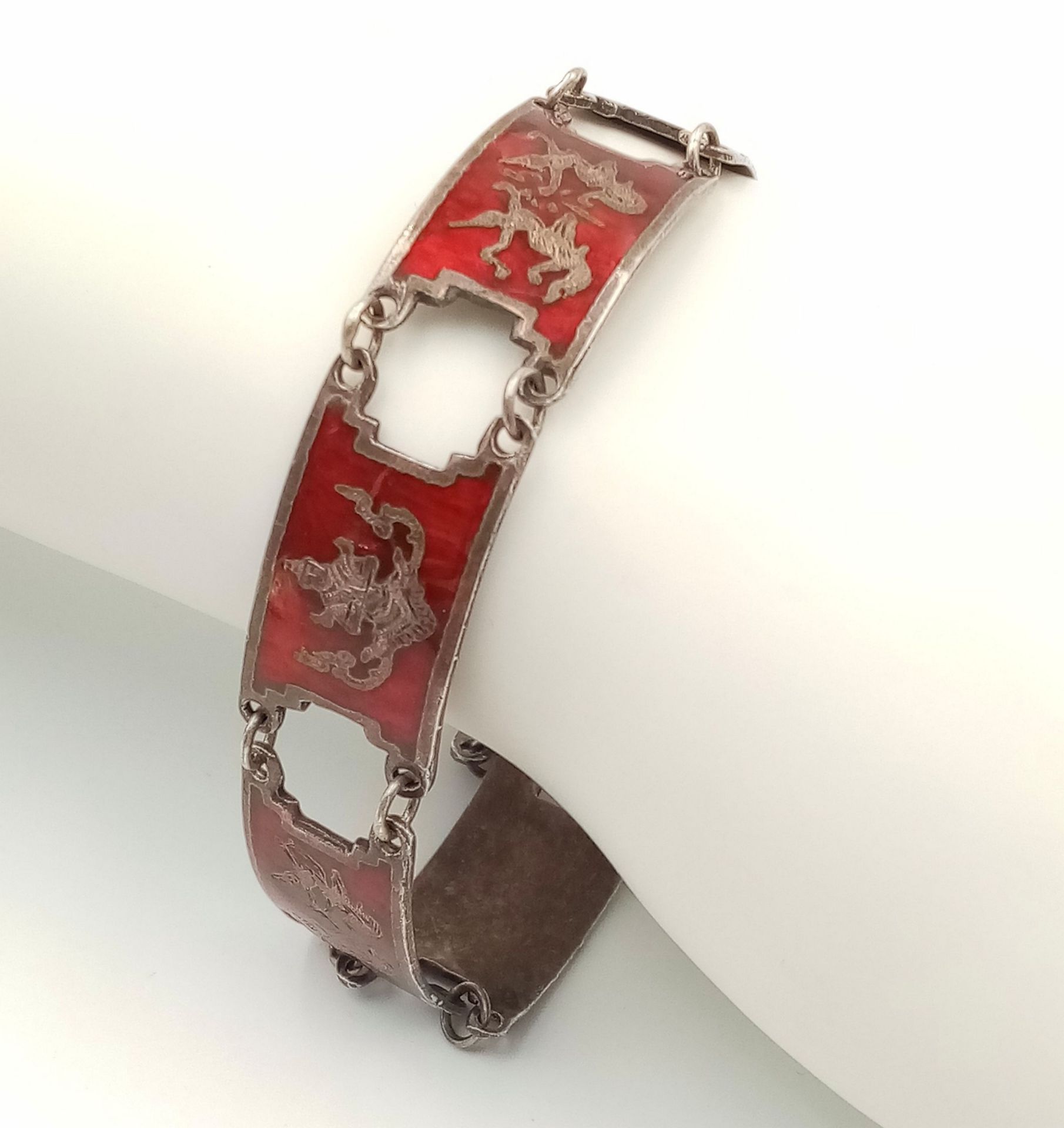 A STERLING SILVER INDIAN RED ENAMELLED BRACELET -FEATURING VARIOUS GODS. 20.3G