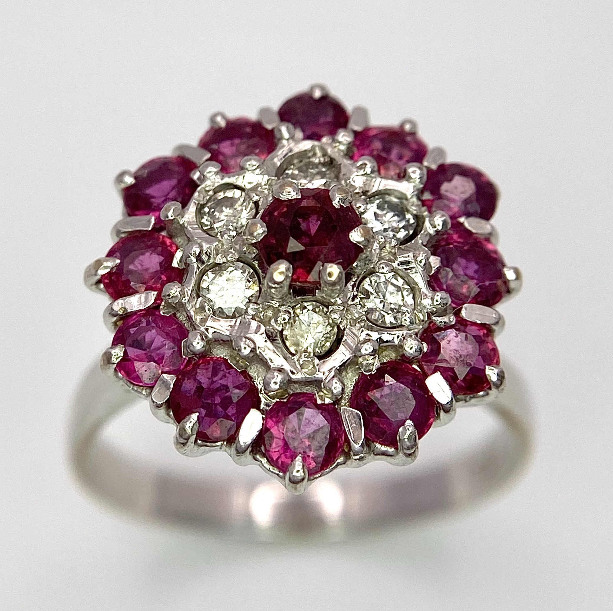 A Gorgeous 18K White Gold, Ruby and Diamond Ring. Floral design on an elevated setting. 14 rubies