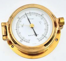 A Nautical, polished brass, KELVIN HUGHES barometer, having the shape of a ship-cabin’s porthole,