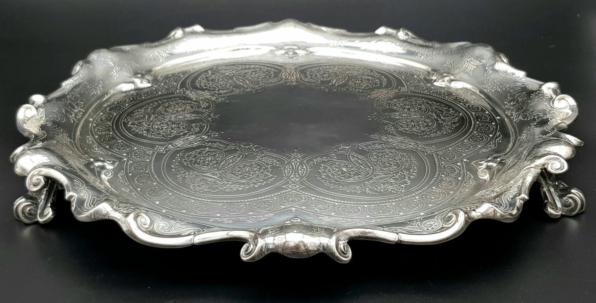 A 761gms solid silver Salva with scrolled edges and hand chased intricate decoration and