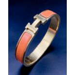 A Hermes Gold Plated and Inlaid Orange Enamel Bangle. 6cm inner diameter. Comes with original Hermes