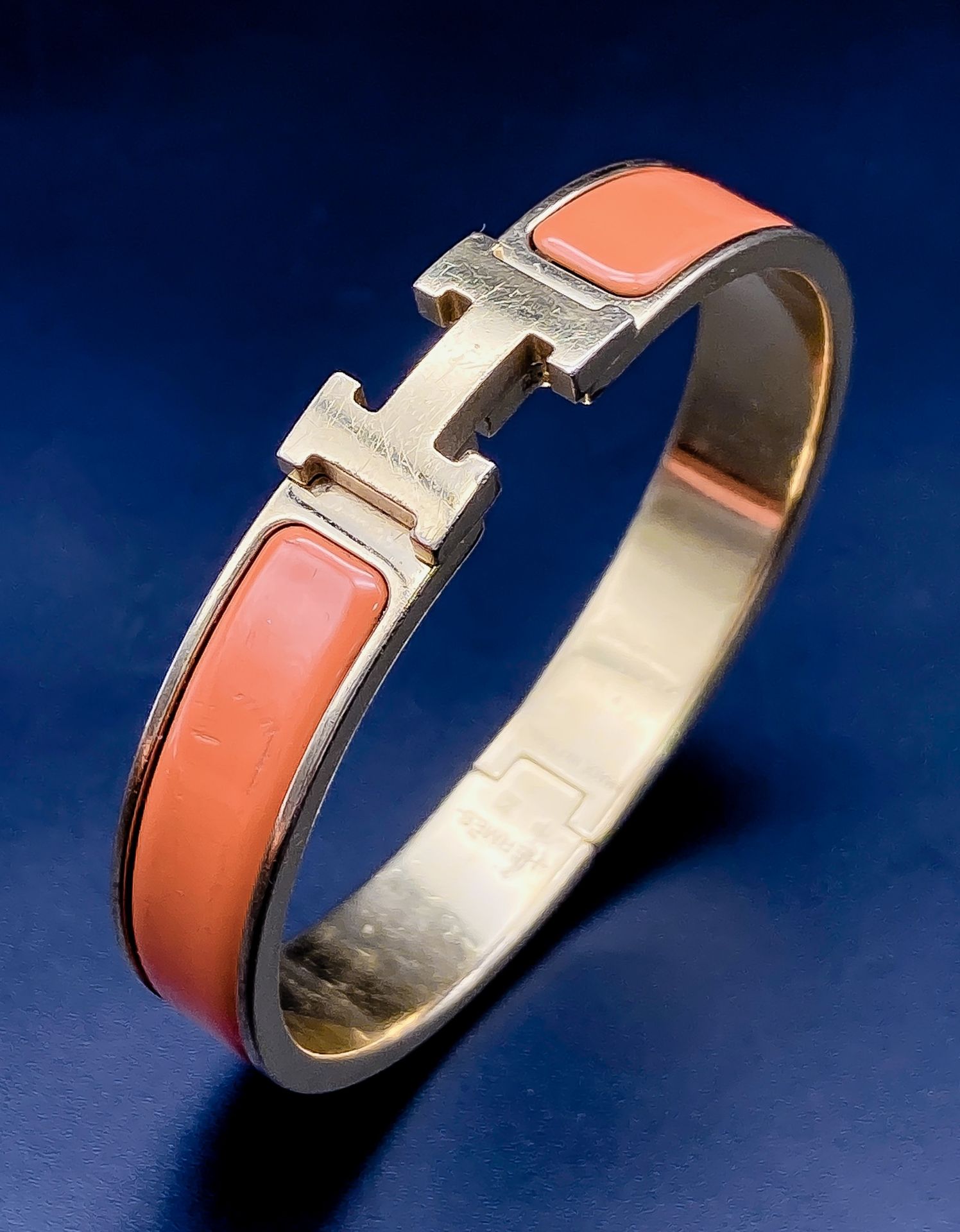 A Hermes Gold Plated and Inlaid Orange Enamel Bangle. 6cm inner diameter. Comes with original Hermes