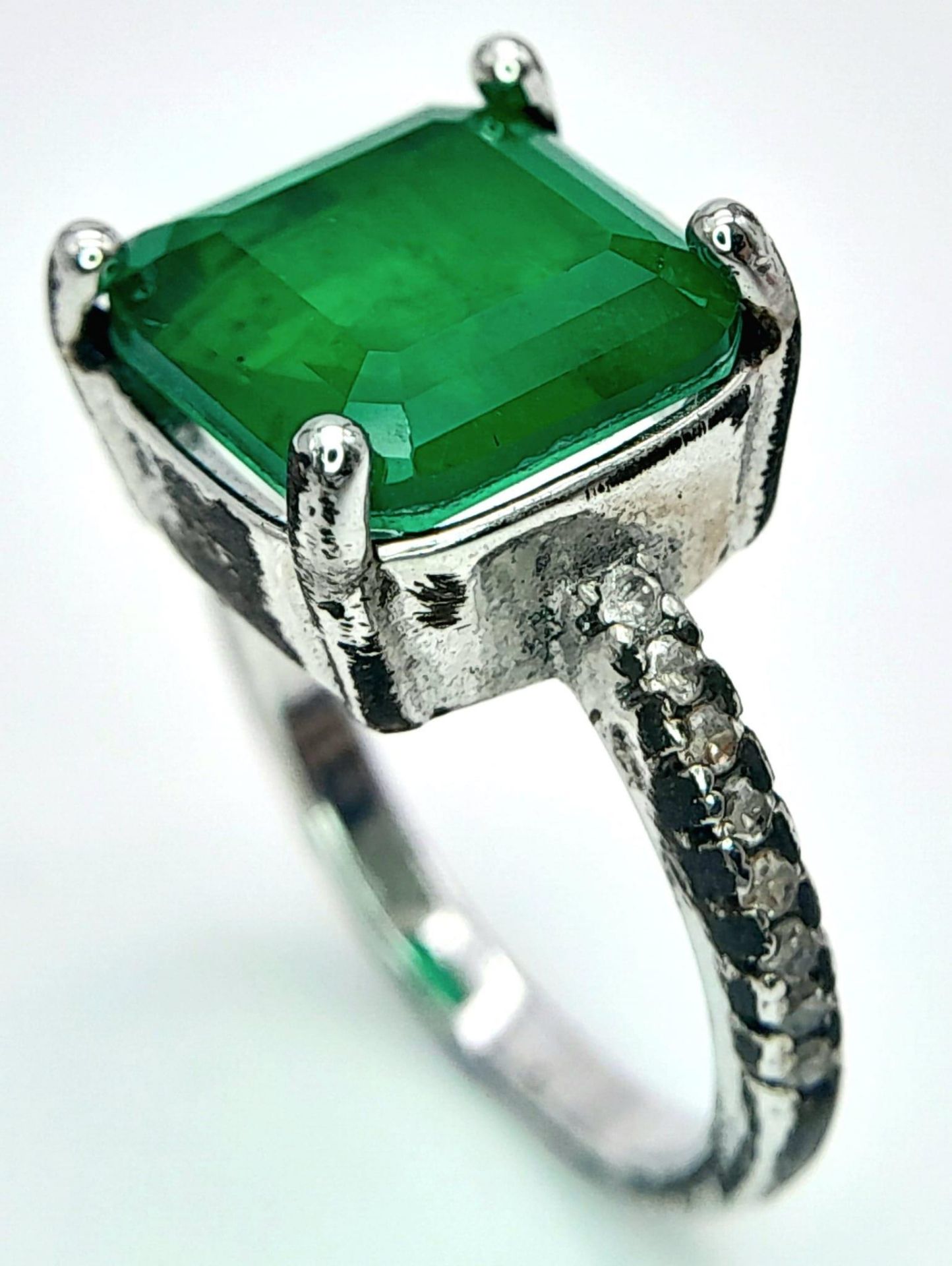 A sterling silver ring with an emerald cut green stone and cubic zirconia on the shoulders. Size: N, - Image 5 of 7