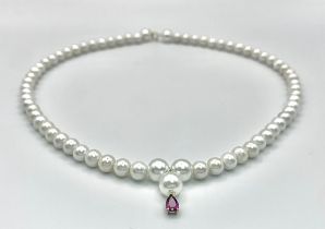 A cultured pearl necklace with a 14 K yellow gold clasp and a small amethyst pendant. Length: 43 cm,