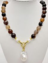 A Striped Agate Beaded Necklace with a Baroque Pearl Hanging Pendant. Gilded clasp. White stone