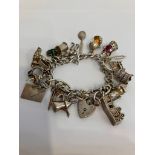 Vintage SILVER CHARM BRACELET complete with safety chain , to include 18 x interesting and unusual