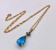 A Swiss Blue Topaz 9K Gold Pendant on a 9K Singapore Chain. Pendant -3cm. Chain -58cm. 4.94g total