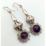 A Pair of Sterling Silver and Amethyst Drop Earrings. Decorative 4cm drops with amethyst cabochons.