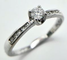 AN 18K WHITE GOLD DIAMOND SOLITAIRE RING - WITH DIAMOND SHOULDERS. 0.25CT. 1.9G. SIZE L