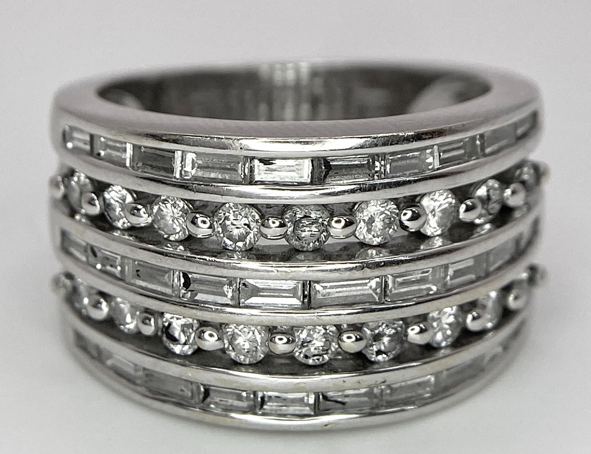 AN 18K WHITE GOLD 5 ROW DIAMOND RING. MIXTURE OF ROUND BRILLIANT CUTS AND BAGUETTE CUT DIAMONDS.