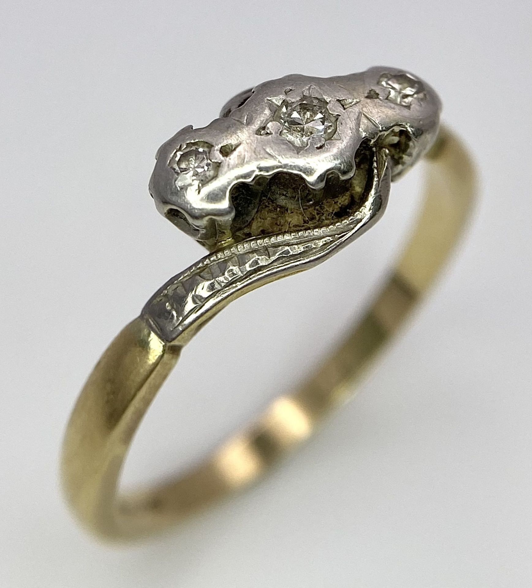 A Vintage 18K Yellow Gold, Platinum and Old Cut Diamond Crossover Ring. Three old cut gypsy-set