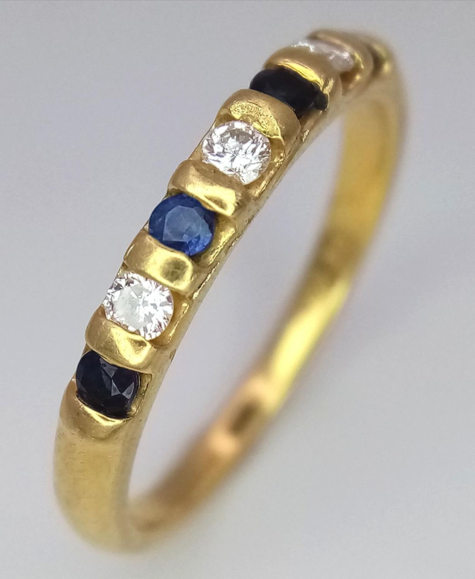 AN 18K YELLOW GOLD DIAMOND & SAPPHIRE BAND RING. 0.15ctw, size M, 2.5g total weight. Ref: SC 9048