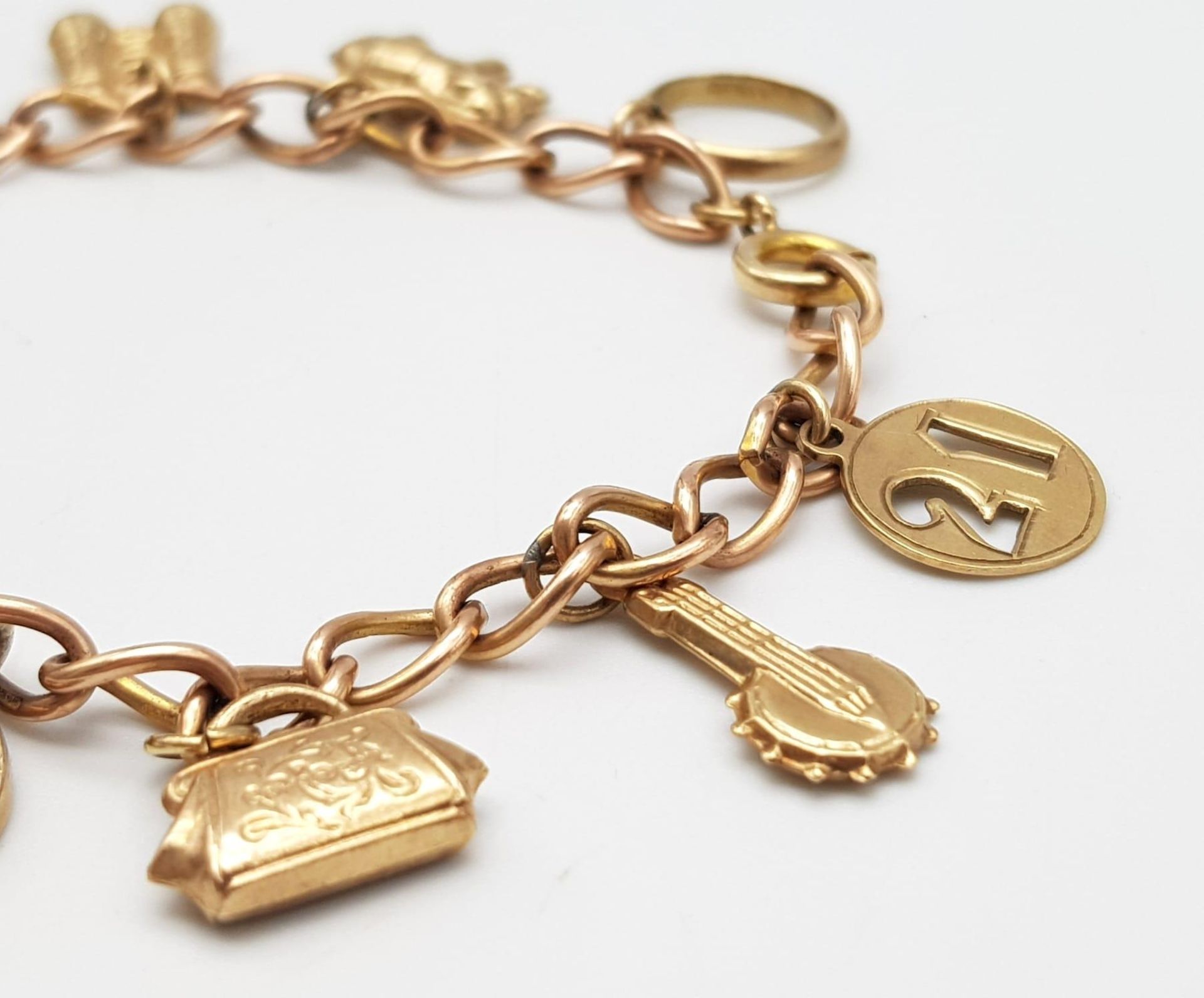 A 9K Gold Charm Bracelet. 10 charms including: 10 shilling note, handbag and binoculars! 18cm - Image 2 of 6