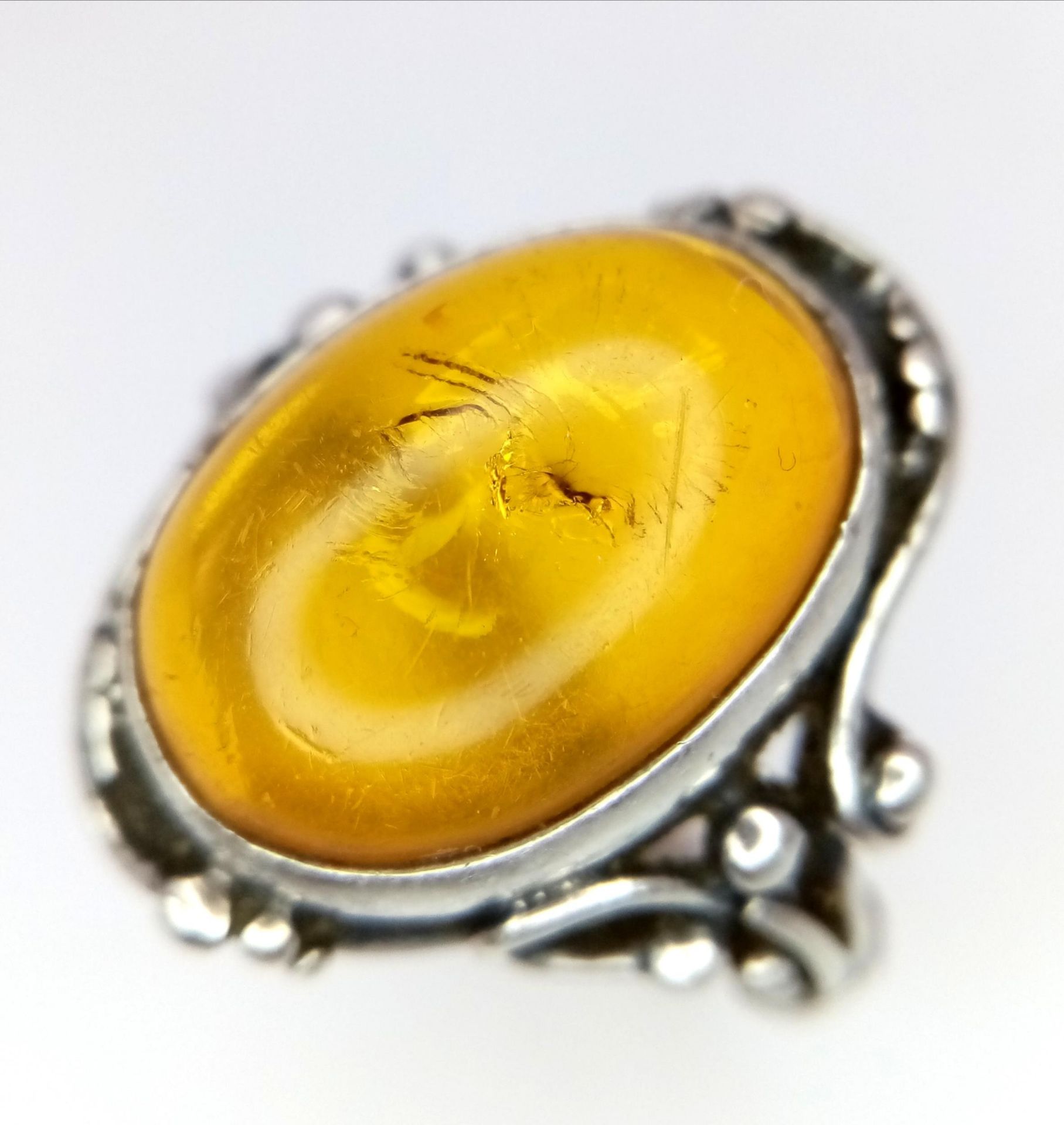 A Vintage or Antique, Ornate Mounted, Silver Amber Cabochon Ring Size S. Set with a 1.8cm Long Amber - Image 4 of 5